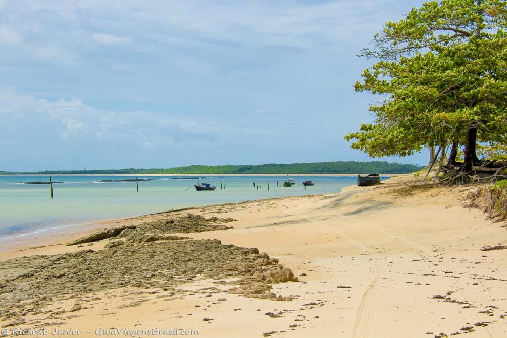 Imagem do mar azulado com barcos no mar da Praia Corumbau.